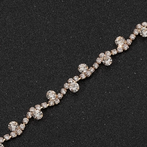 Macro detail of wave-shaped golden rhinestone chain with sparkling crystal stones