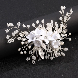 Detailed view of bridal hair comb with white matte flowers, pearls, and crystals