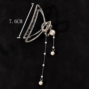 Detail view of 7.6cm silver metal hair claw clip with elegant pearl tassel pendant