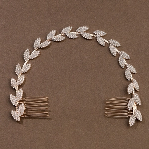 Dettaglio di un pettine per capelli da sposa con foglie dorate e strass scintillanti
