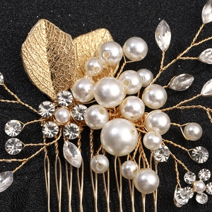 Detail shot of golden alloy leaf hair comb with handmade white pearls and rhinestones