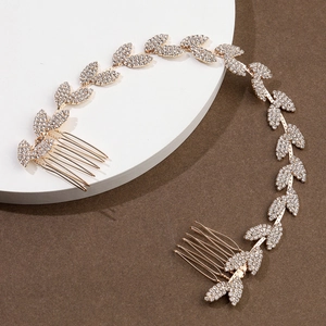 Dettaglio dell'accessorio capelli sposa dorato a foglia con strass e pettini laterali