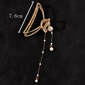 Detailed view of golden metal hair claw with elegant pearl tassels and 7.6cm size marker
