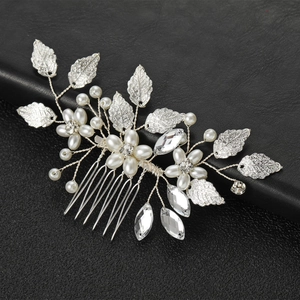 Dettaglio macro del pettine per capelli in argento con strass e perle bianche
