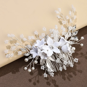 Detail of silver bridal hair comb with white ceramic flowers, pearls and rhinestones