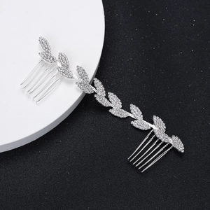 Macro view of silver bridal hair comb with rhinestone leaf pattern and dual metal prongs