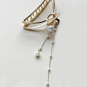 Elegant gold metal hair claw clip featuring white pearl tassels in a minimalist design