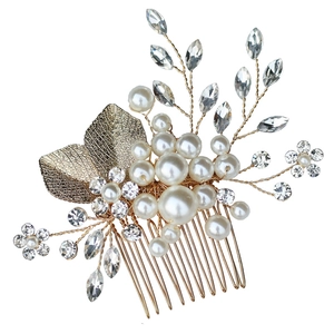 Macro view of crystal rhinestones and pearls on a gold leaf bridal hair comb accessory