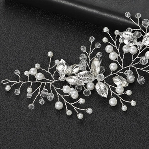 Détail de vigne de cheveux argentée avec feuilles, perles et cristaux sur cuir noir