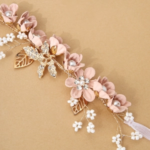 Detailed shot of pink floral wrist corsage with gold leaves and pearl accents