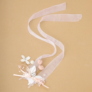 Detail of pink organza ribbon wrist flower with pearls and rhinestone for bridesmaids