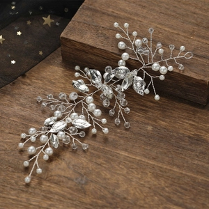 Détail de vigne de cheveux argentée avec perles et cristaux sur fond en bois vintage