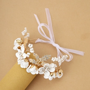 Elegant floral wrist corsage with white fabric flowers, pearls, and pink ribbon for weddings