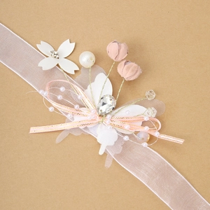 Detail of handmade floral wrist corsage with pink fabric buds and pearl accents