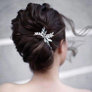 Épingle à cheveux feuilles argentées avec strass opales sur un chignon élégant
