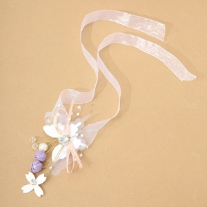 Detailed macro view of organza wrist flower with artificial pearls and heart crystal