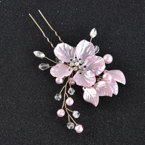 Détail d'épingle à cheveux fleur rose avec perles et strass sur fourche dorée