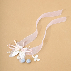 Elegant floral wrist corsage with pink organza ribbon, pearls, and crystals for weddings