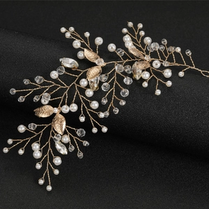 Vigne de cheveux de mariée dorée avec perles et cristaux sur support noir élégant