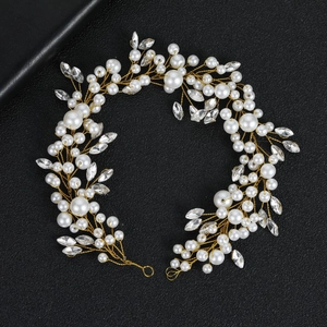 Detail of handmade pearl and marquise crystal hair vine with gold wire for wedding hairstyles