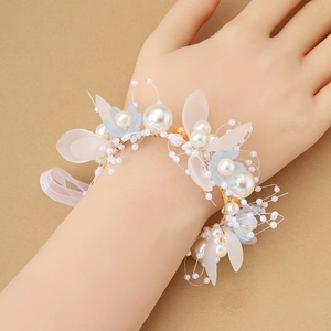 Ramillete de muñeca con pétalos blancos y azules, perlas y cintas translúcidas