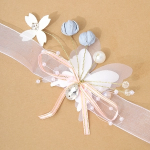 Elegant white floral wrist corsage with blue buds and pink silk bow for bridesmaids