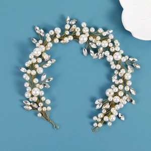 Close-up of handmade pearl and marquise crystal bridal hair vine with golden wire