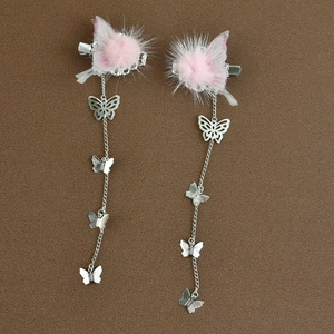 Detail von rosa Bommel-Haarspangen mit langen Silberketten und Schmetterlingen