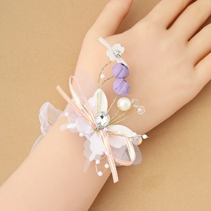 Elegant lavender floral bridal wrist corsage with pearls, lace, and butterfly ribbons