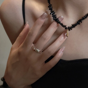 Gros plan d'un collier de perles noires avec pendentif goutte dorée sur un mannequin