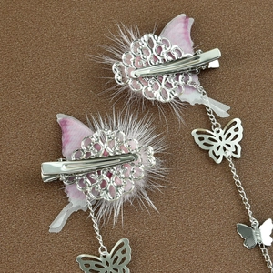 Detail von Schmetterling-Haarspangen mit rosa Flügeln, Pelzbesatz und langen Quasten