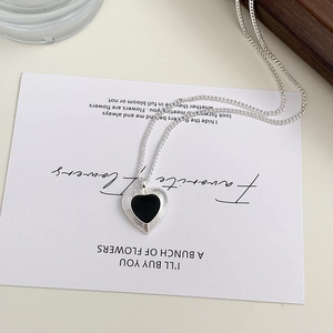 Minimalist silver heart pendant necklace with black enamel drip and textured edge details