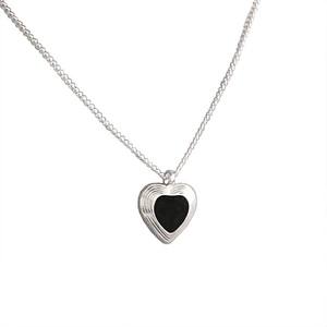 Minimalist silver heart necklace with black enamel inlay and radial textured edges