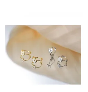 Détail des boucles d'oreilles créoles fleurs en or et argent avec pétales émaillés