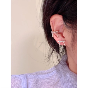 Vue rapprochée d'un clip d'oreille nœud en argent porté sur le cartilage de l'oreille