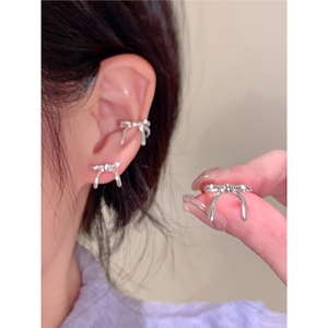 Gros plan d'un ensemble de boucles d'oreilles et de bagues d'oreille nœud argent
