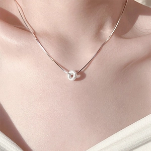 Minimalist silver frosted donut pendant necklace worn by a model on a delicate chain