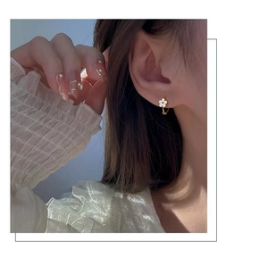 Gros plan de boucles d'oreilles à fleurs blanches portées par un mannequin pour l'été