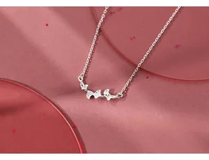 Close-up of silver ginkgo leaf pendant with realistic texture on a fine link chain