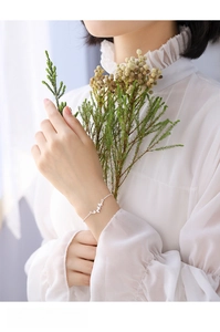 Close-up of minimalist ginkgo leaf bracelet on female wrist with elegant silver details