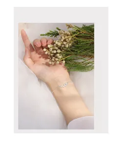 Detail of silver ginkgo leaf bracelet with marquise-cut zircon stones on model wrist