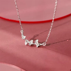 Minimalist silver ginkgo leaf bracelet featuring three delicate nature-inspired charms