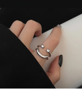 Close-up of minimalist double-layer adjustable silver ring with smiley face design