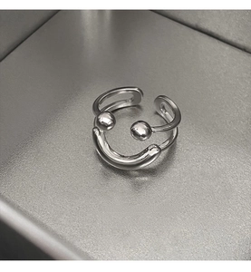 Detail of silver double-layered open ring with polished metal beads and minimalist design