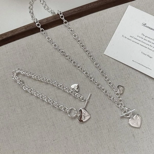 Vue détaillée du pendentif cœur argenté avec gravure lucky sur collier à fermoir OT