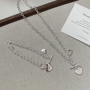 Ensemble collier et bracelet à fermoir en T avec cœur Lucky sur fond minimaliste