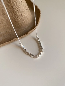 Detailed macro view of S925 sterling silver necklace with small geometric cube beads