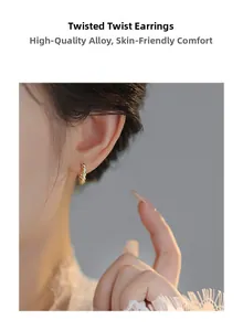 Close-up of model wearing gold twisted hoop earrings made of premium alloy material