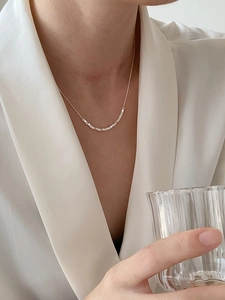 Close-up of minimalist S925 sterling silver square pendant necklace worn by a model