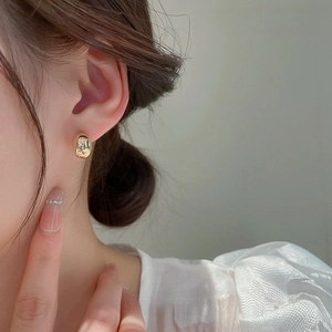 Polished gold bean stud earrings for women with a minimalist metallic mirror finish